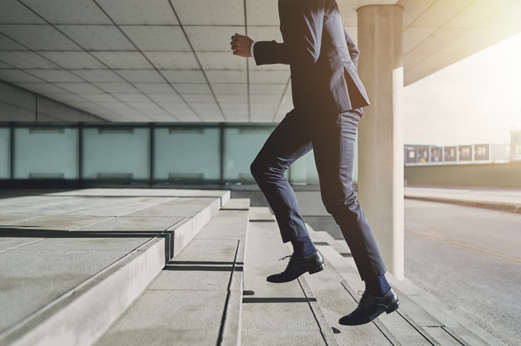 businessman climbing steps, wealth concept
