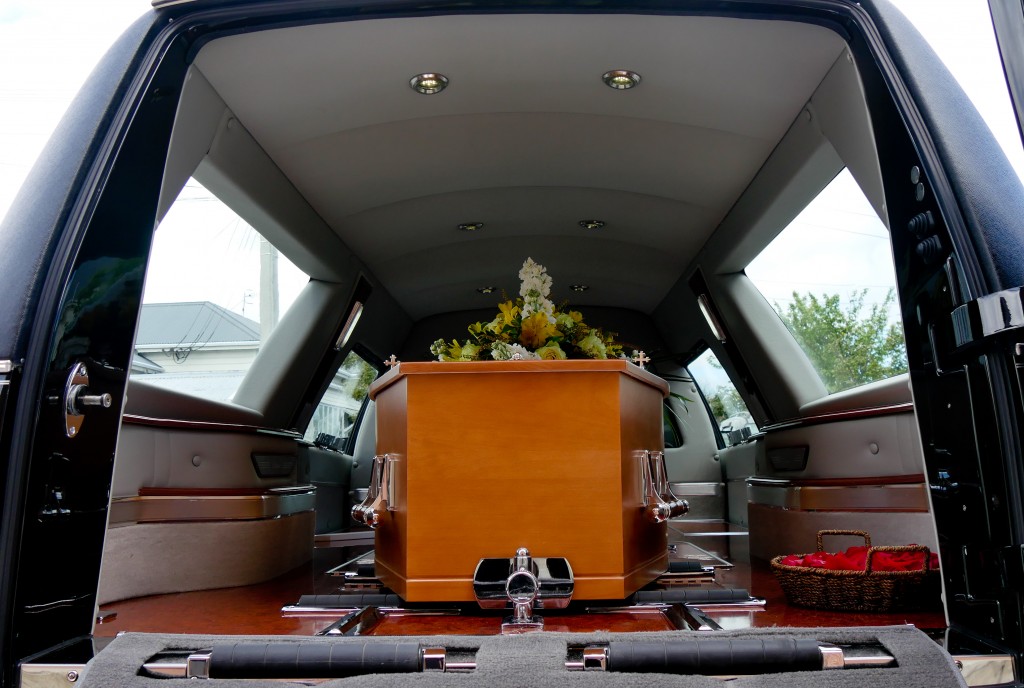 Wooden casket inside a funeral car