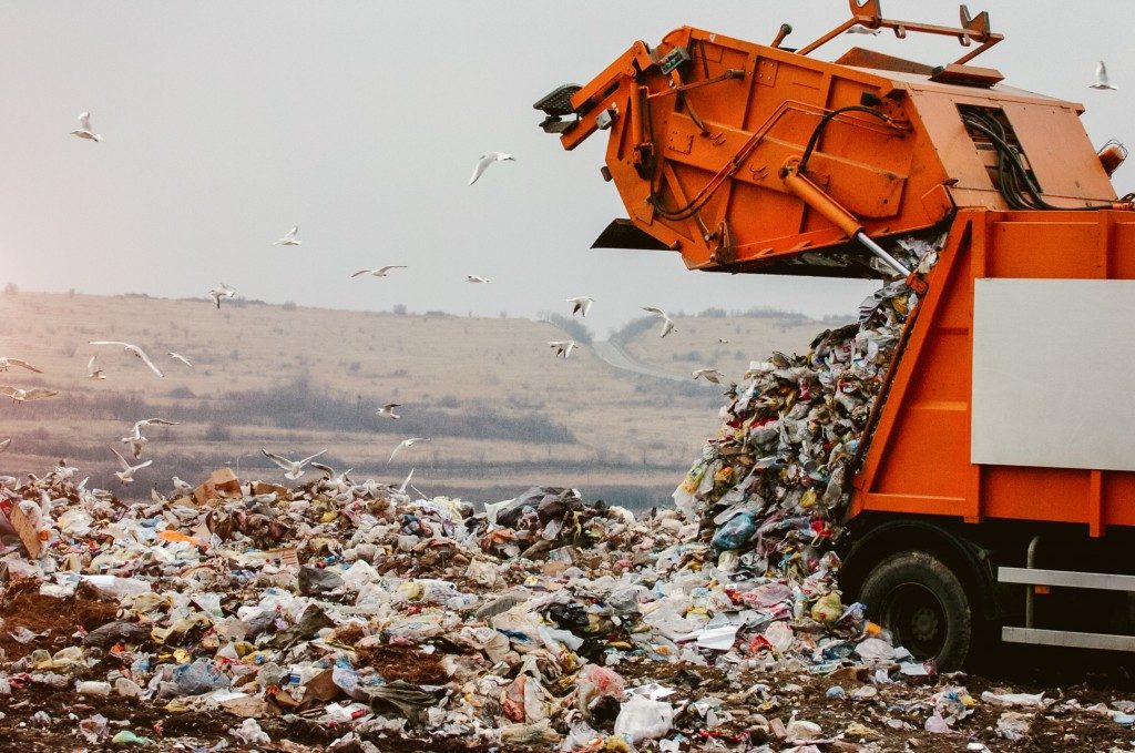 tractor dumping trashed in the landfill