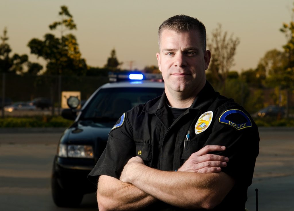 Police man in front of his car