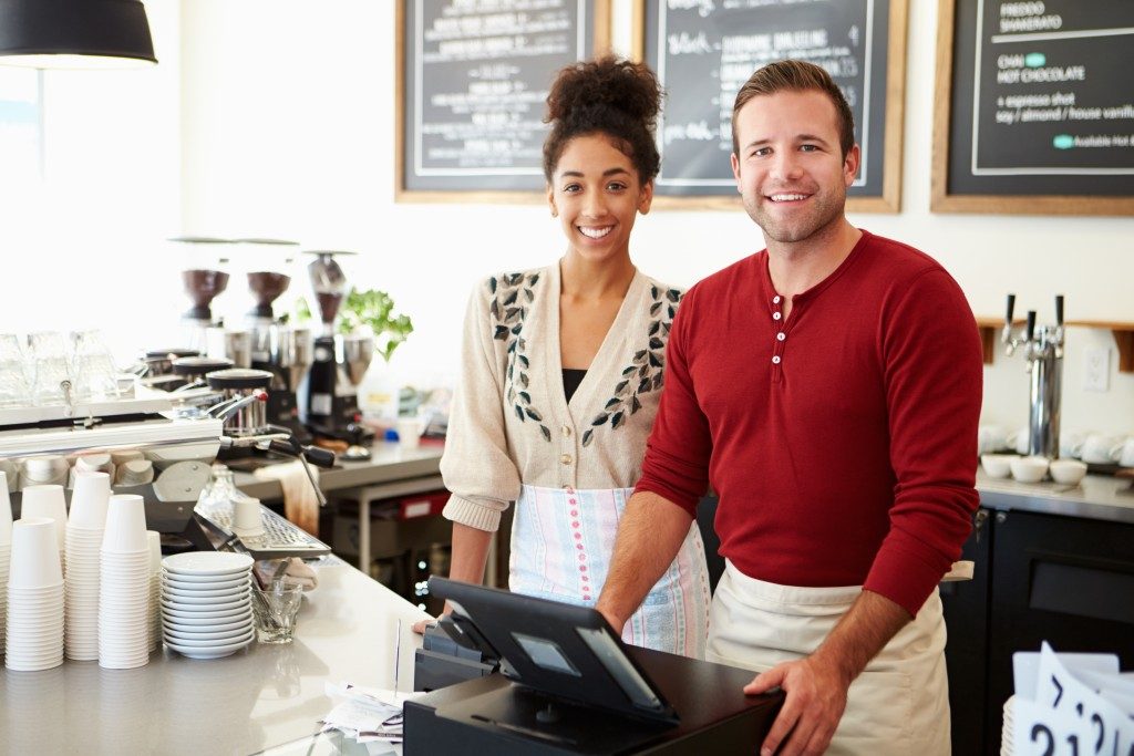 Man and woman by the cashier in cafe