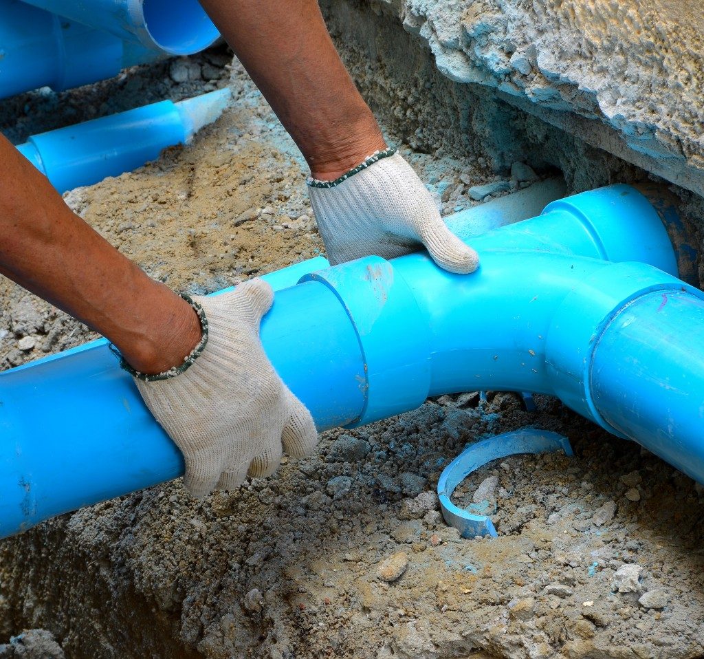 man fixing the underground water pipe