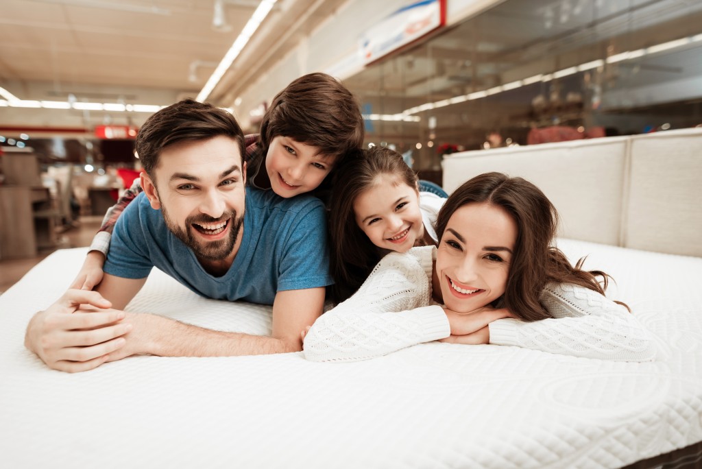 Couple lying down on bed with two kids