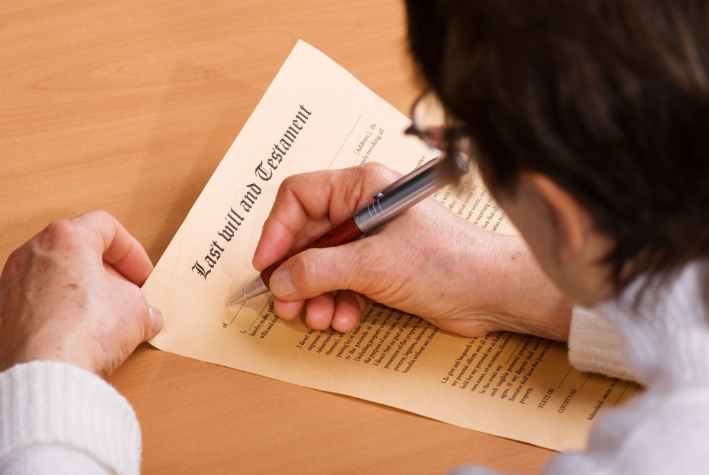 person filling up a last will and testament document