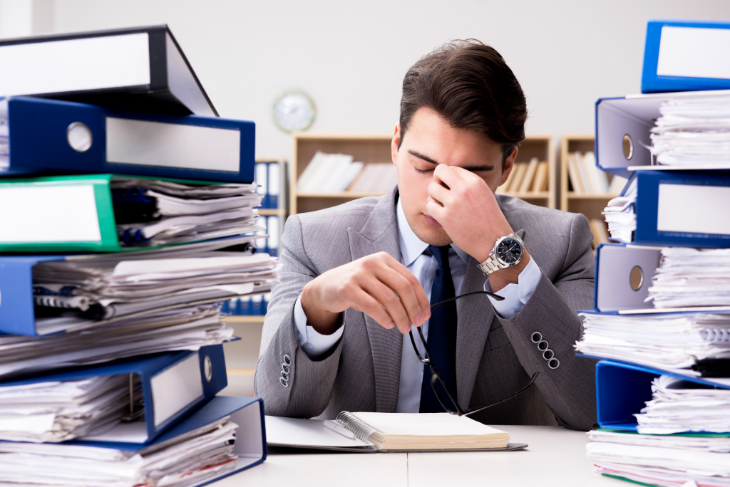 A man holding his forehead while at work