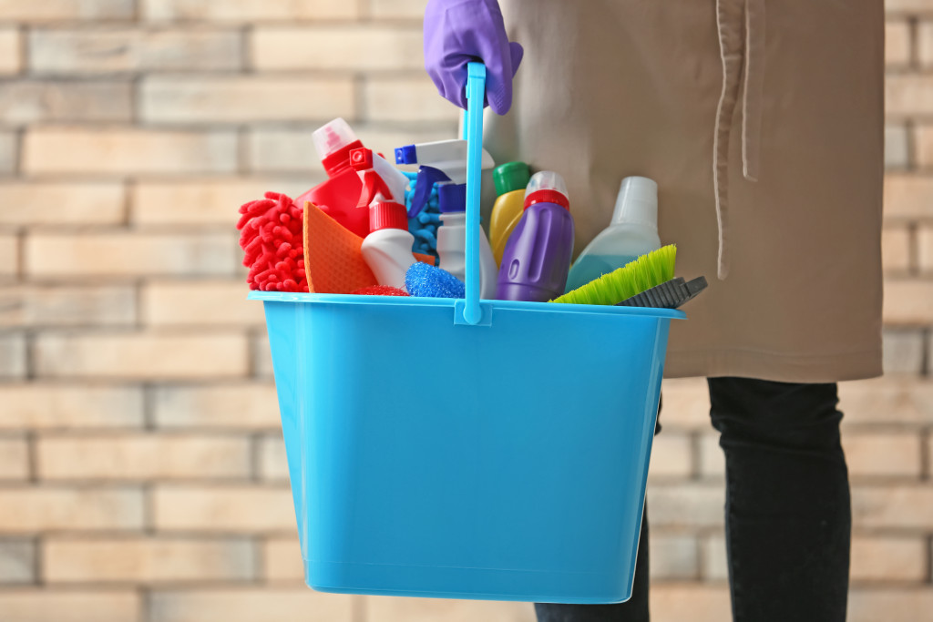 person holding cleaning supplies