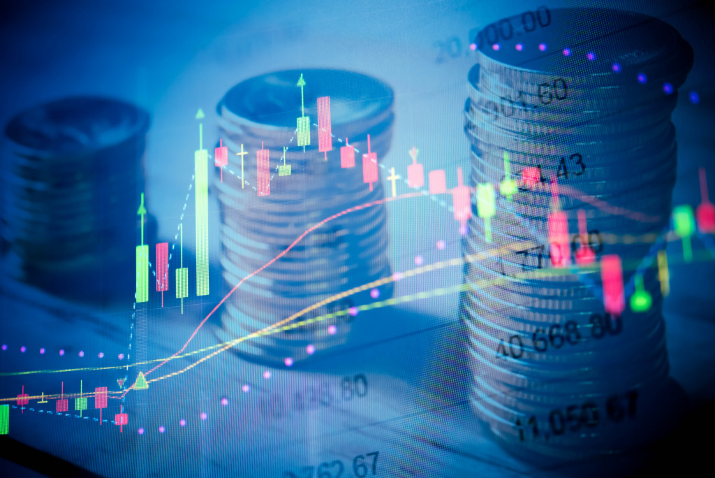 Stacks of coins and a virtual screen showing charts and tables of crypto exchange rates