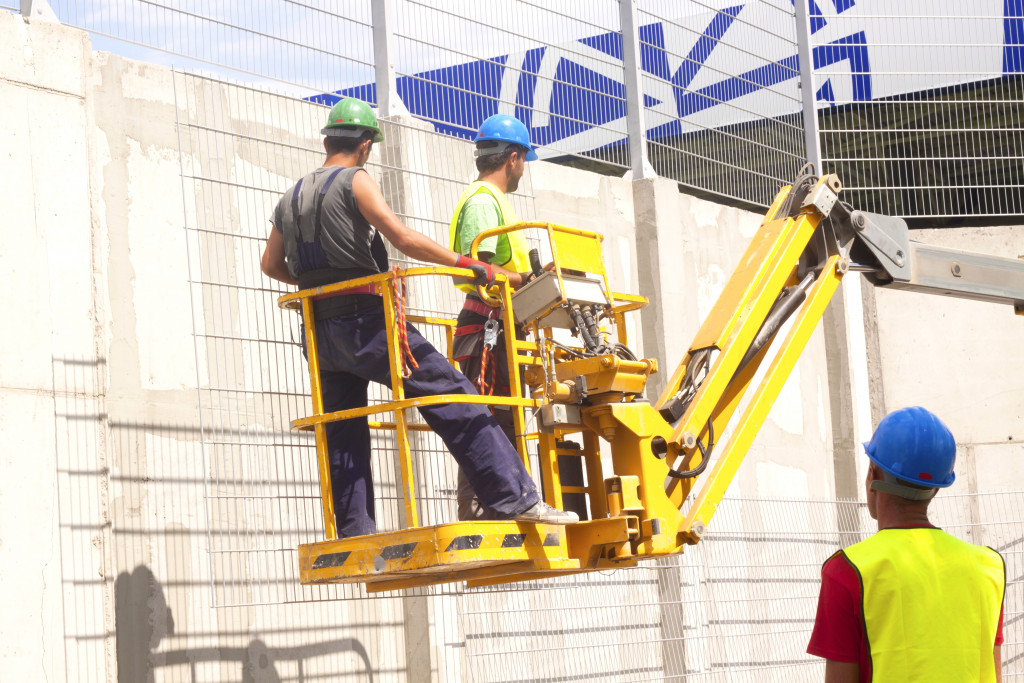 Hydraulic mobile construction platform elevated towards a blue sky with construction workers