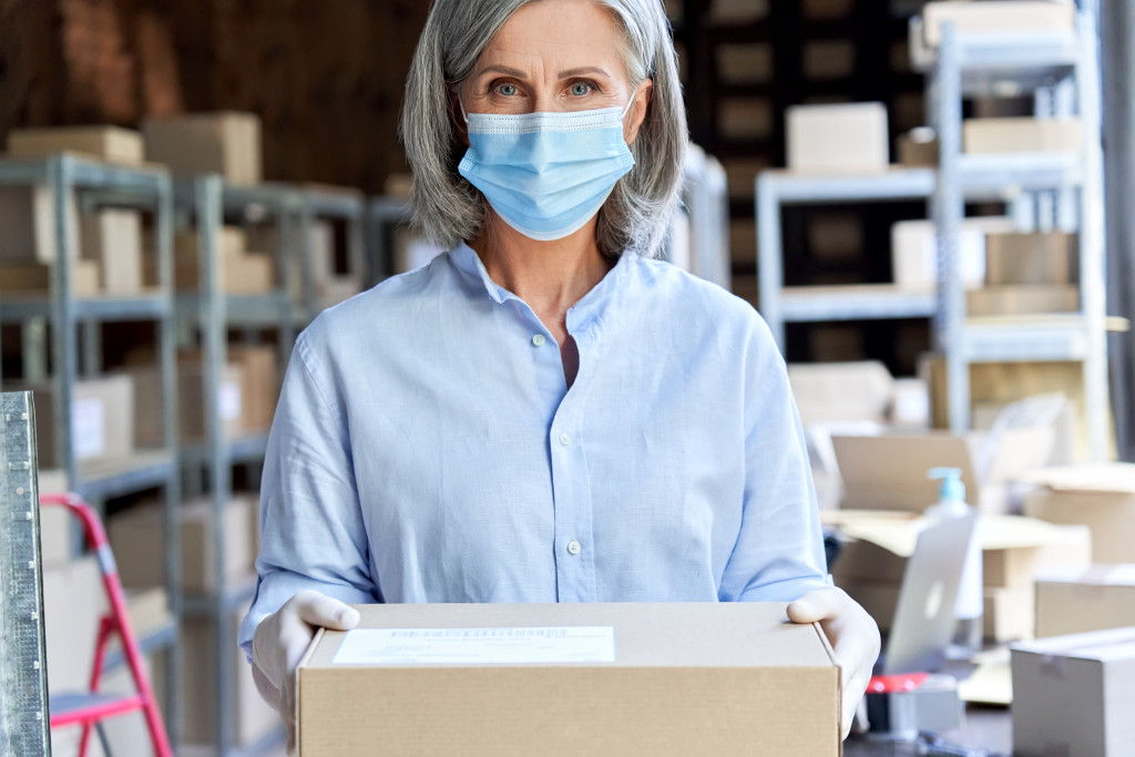 woman in a mask holding a box