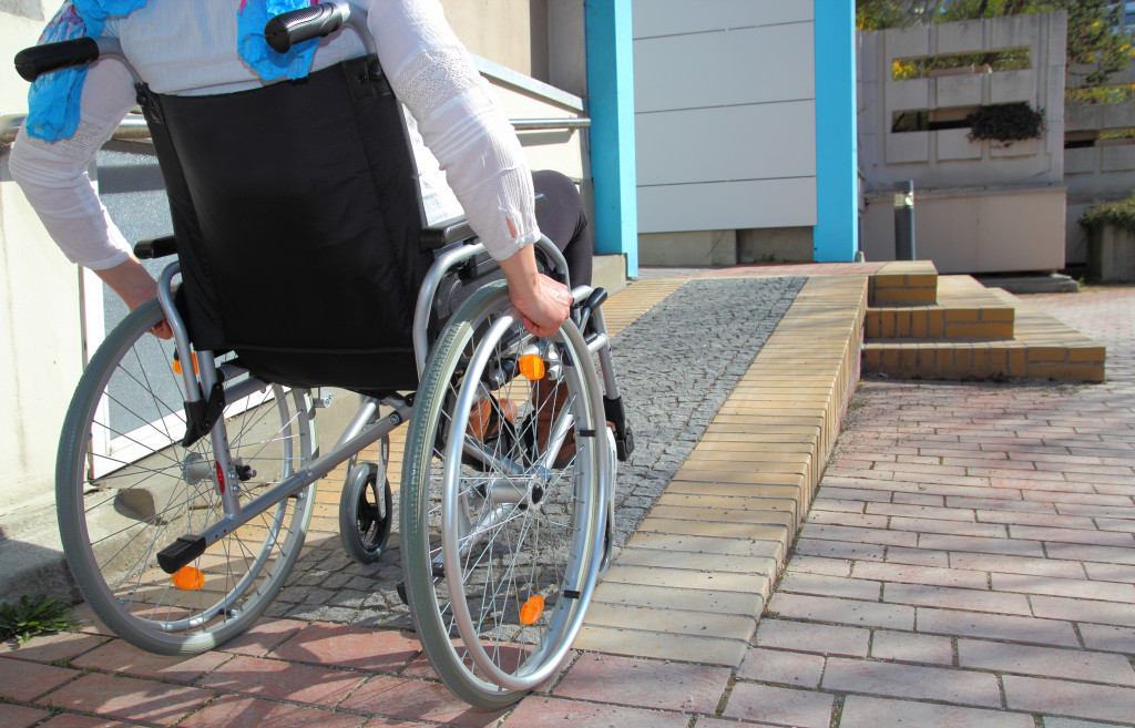 Person in wheelchair using accessibility ramp