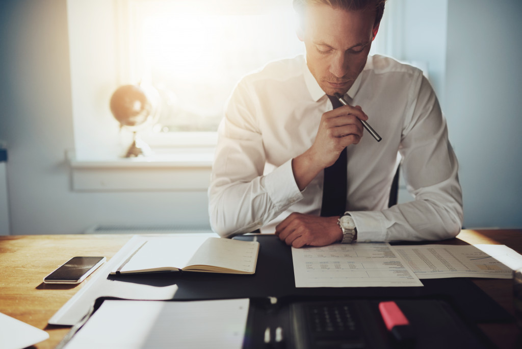 A man sitting in his home and looking at his finances after getting divorce 