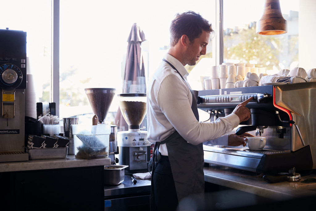 a coffee shop barista using a coffee machine