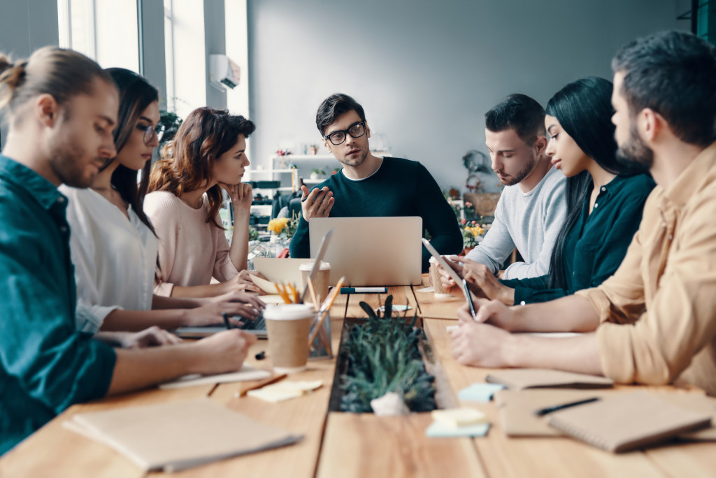 a group of young professionals sat around the meeting table