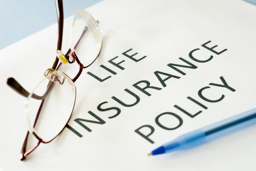 Life insurance policy with spectacles and a pen on it