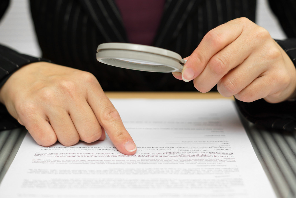 woman reading contract with a magnifying glass