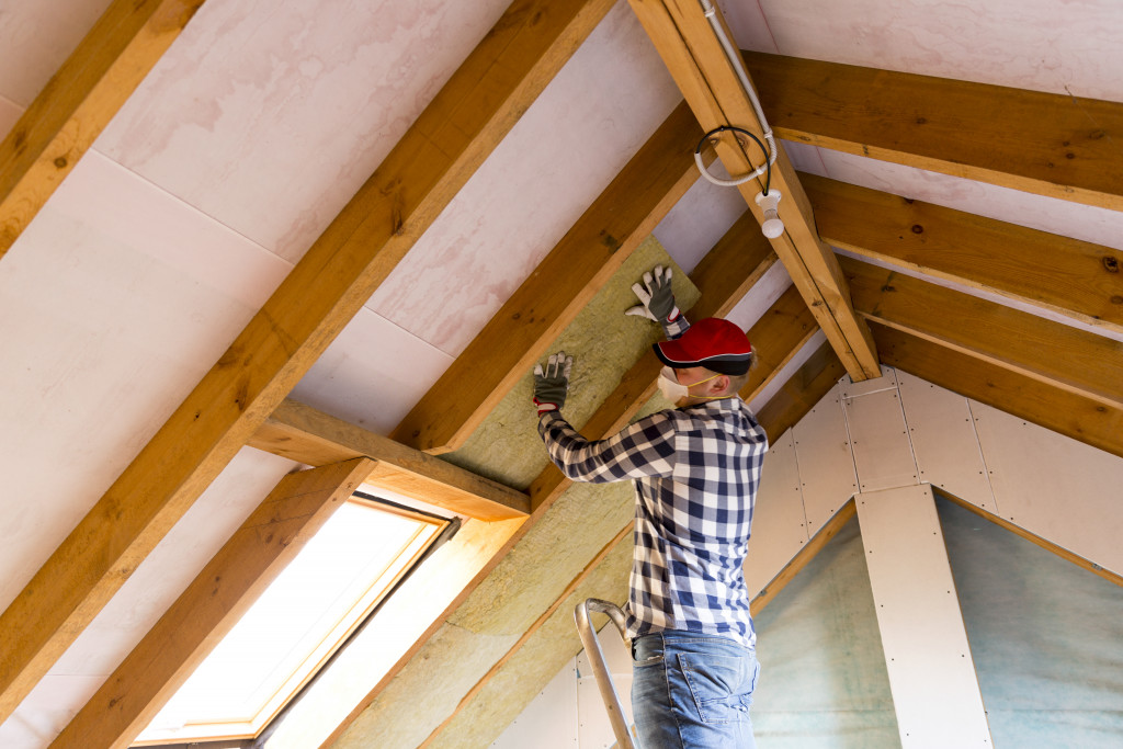 Worker installing insulation in the house.