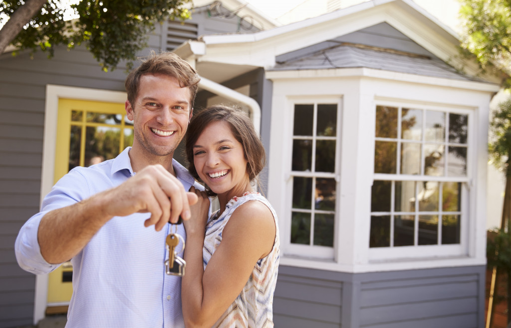 A couple in front of a house holding keys