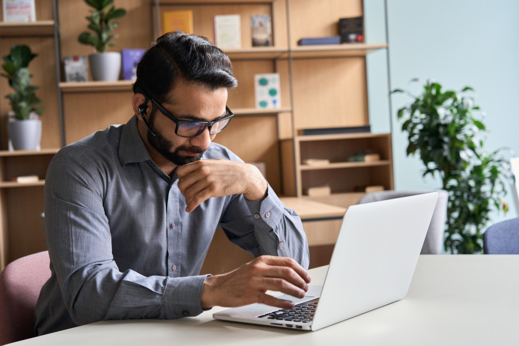 Remote employee working on a table at home using a laptop.