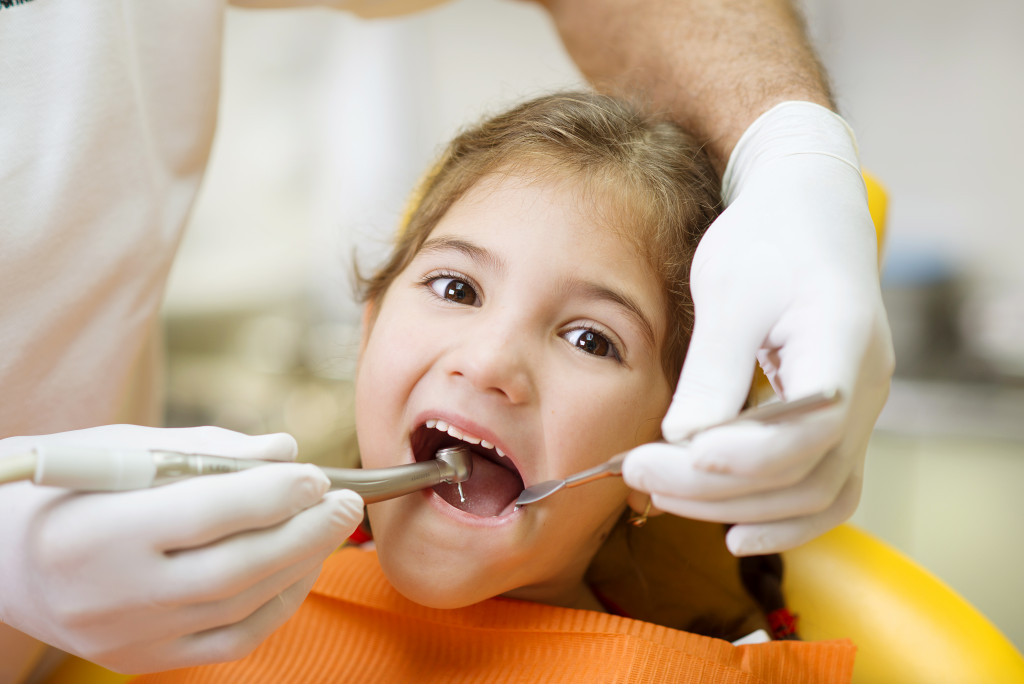 A little girl getting a dental procedure