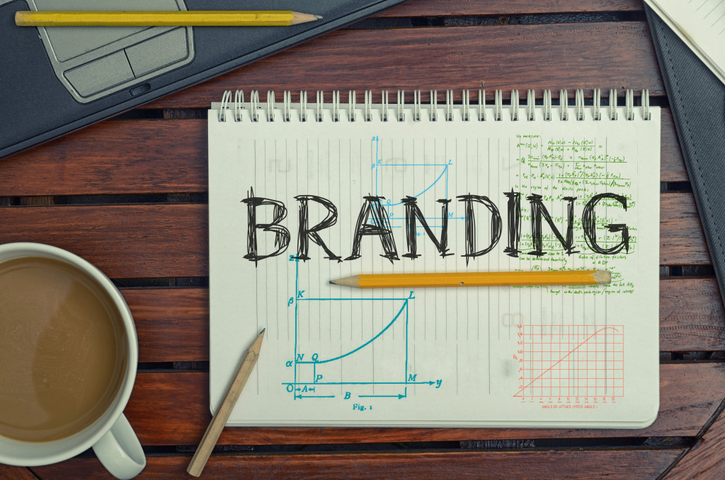 the word branding written in a notebook with coffee and various objects on the side