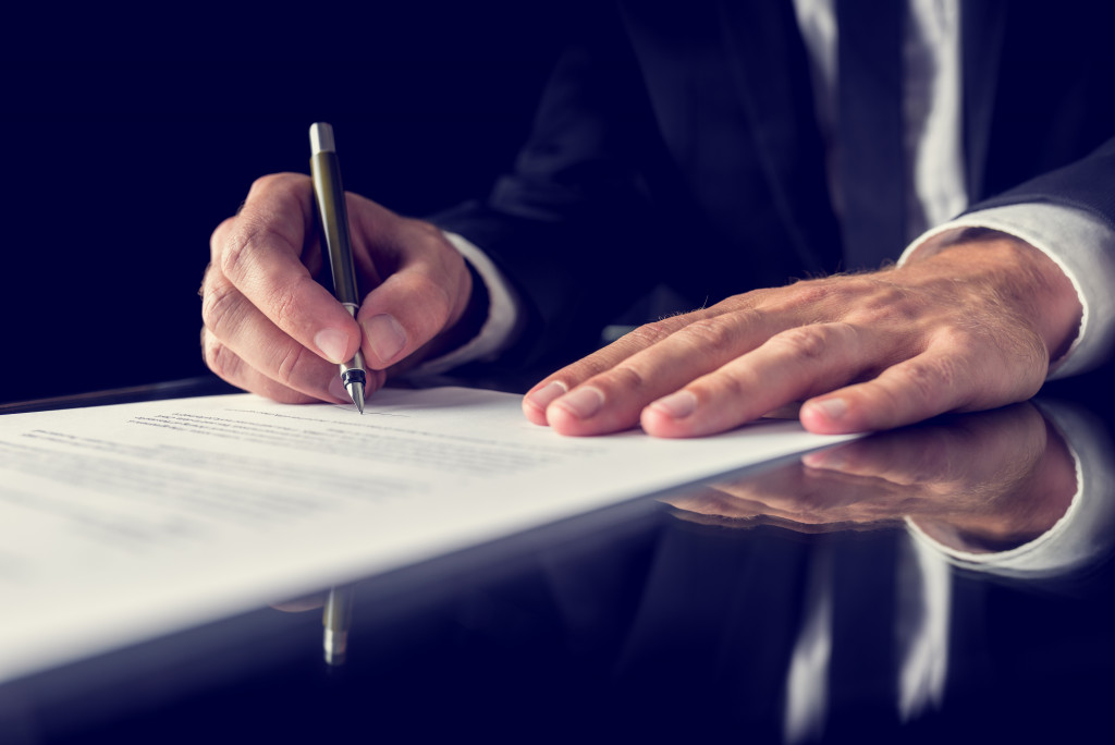 A businessman signing a contract in a dark room