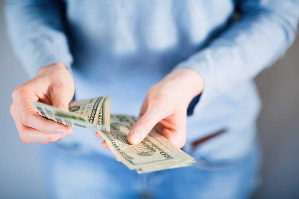 A person counting dollar bills with both hands