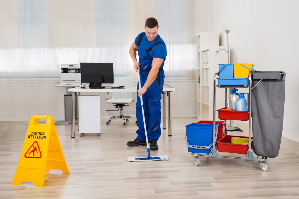 A janitor mopping the floor of an office