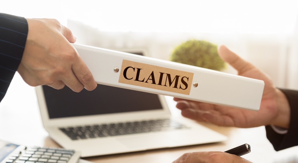 business person handing portfolio of claims to the insurance company