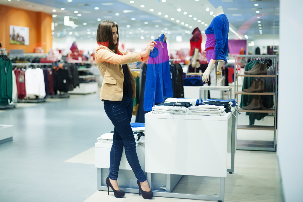 A woman checking out clothes in a department store