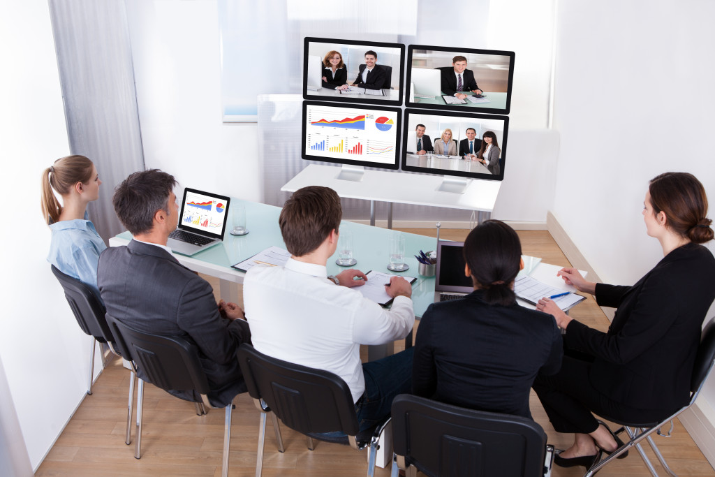 employees sitting together in front of a monitor on a virtual meeting