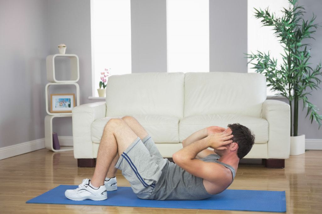 man with floor mat execising at home