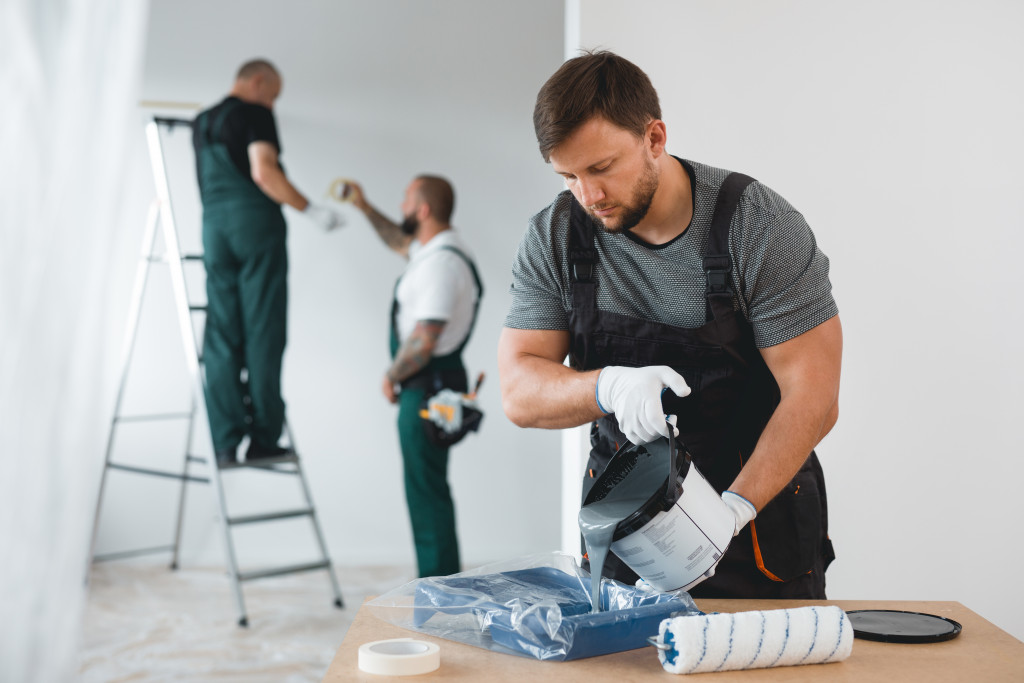 A group of workers painting walls