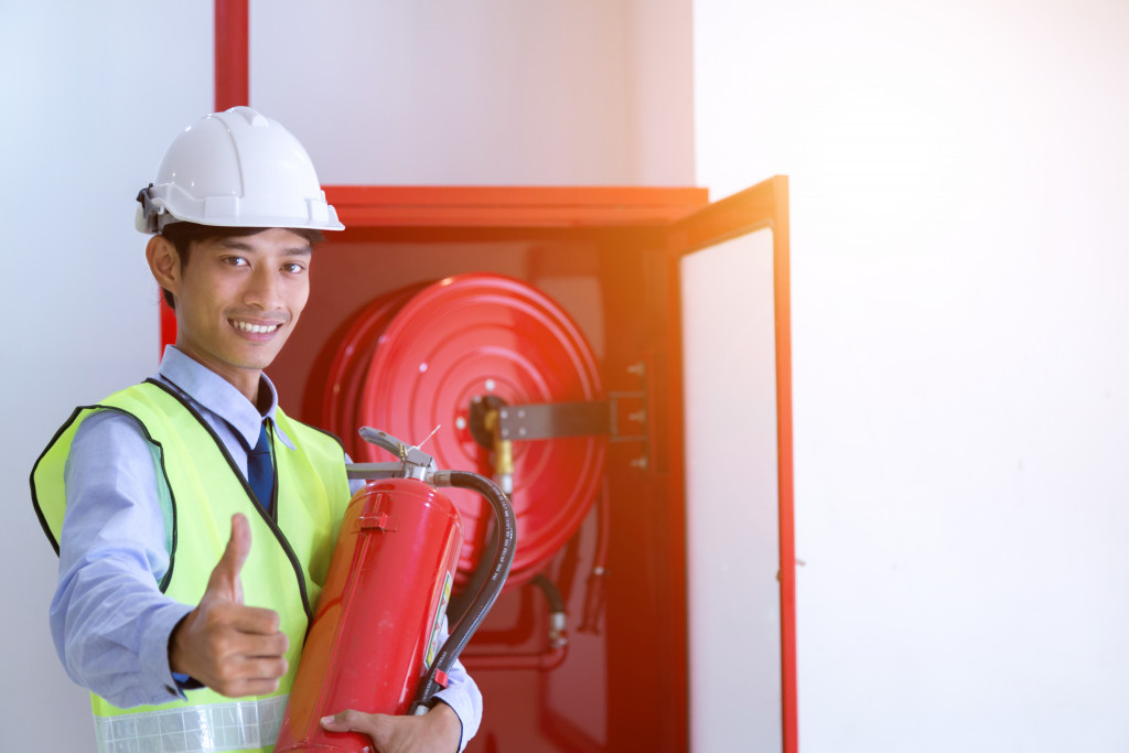 man holding a tank of fire extinguisher 