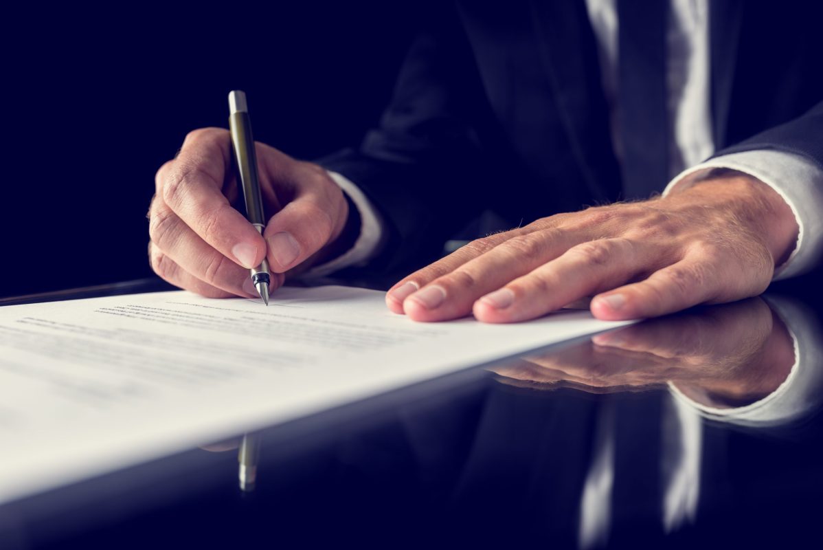 A businessman signing a contract in the dark