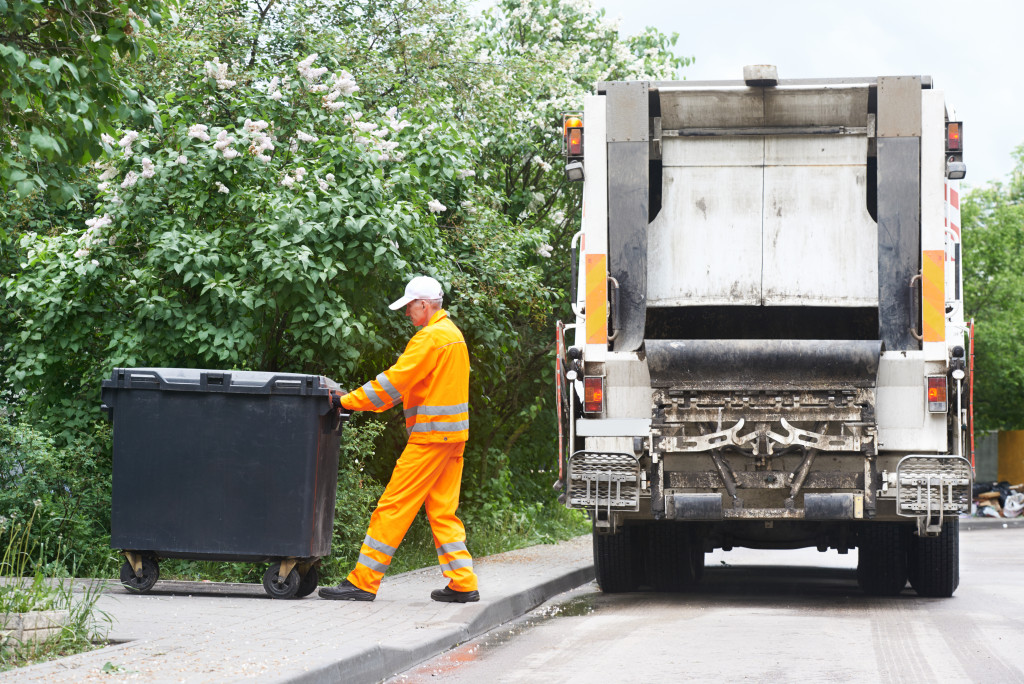 man pushing garbage cart