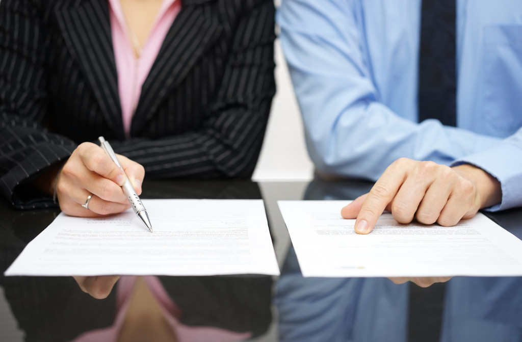 businessman and businesswoman inspecting contract