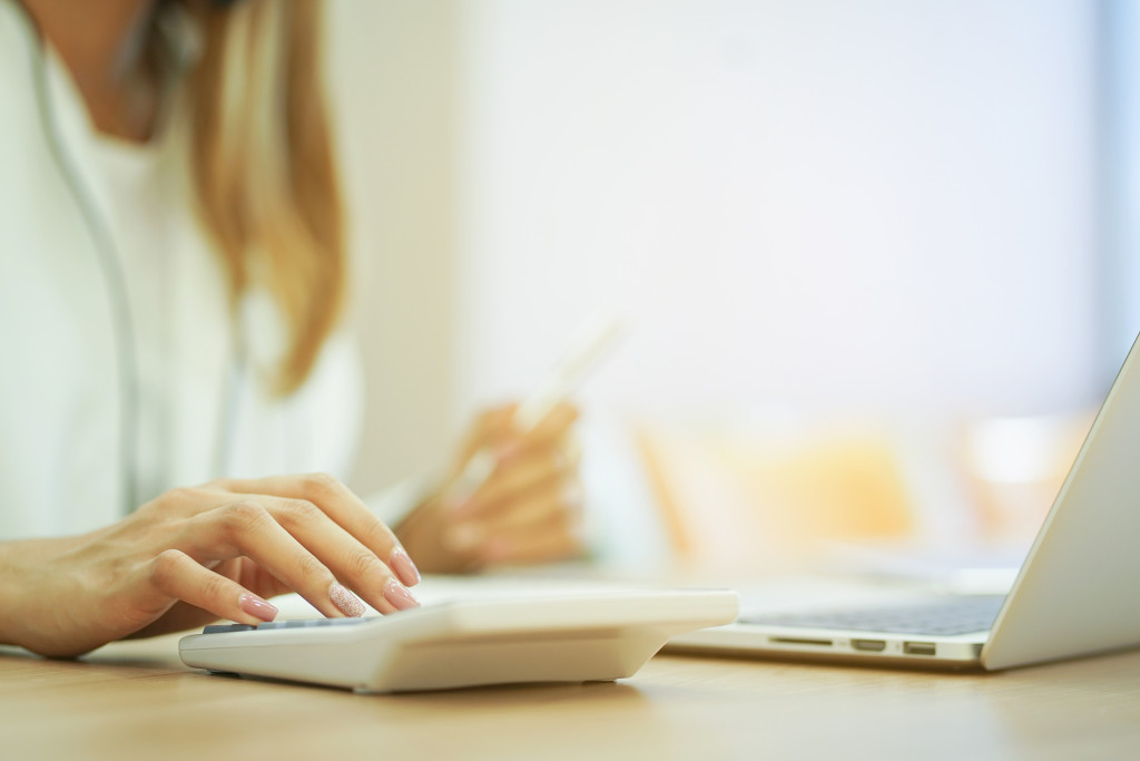 Female business owner establishing a price for services.with a calculator.