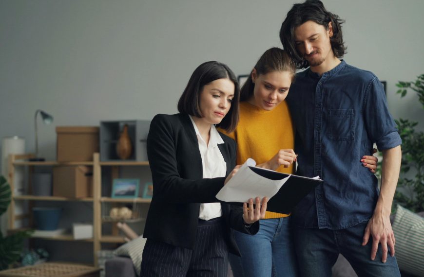 home appraiser and a couple reviewing paperwork on a clipboard